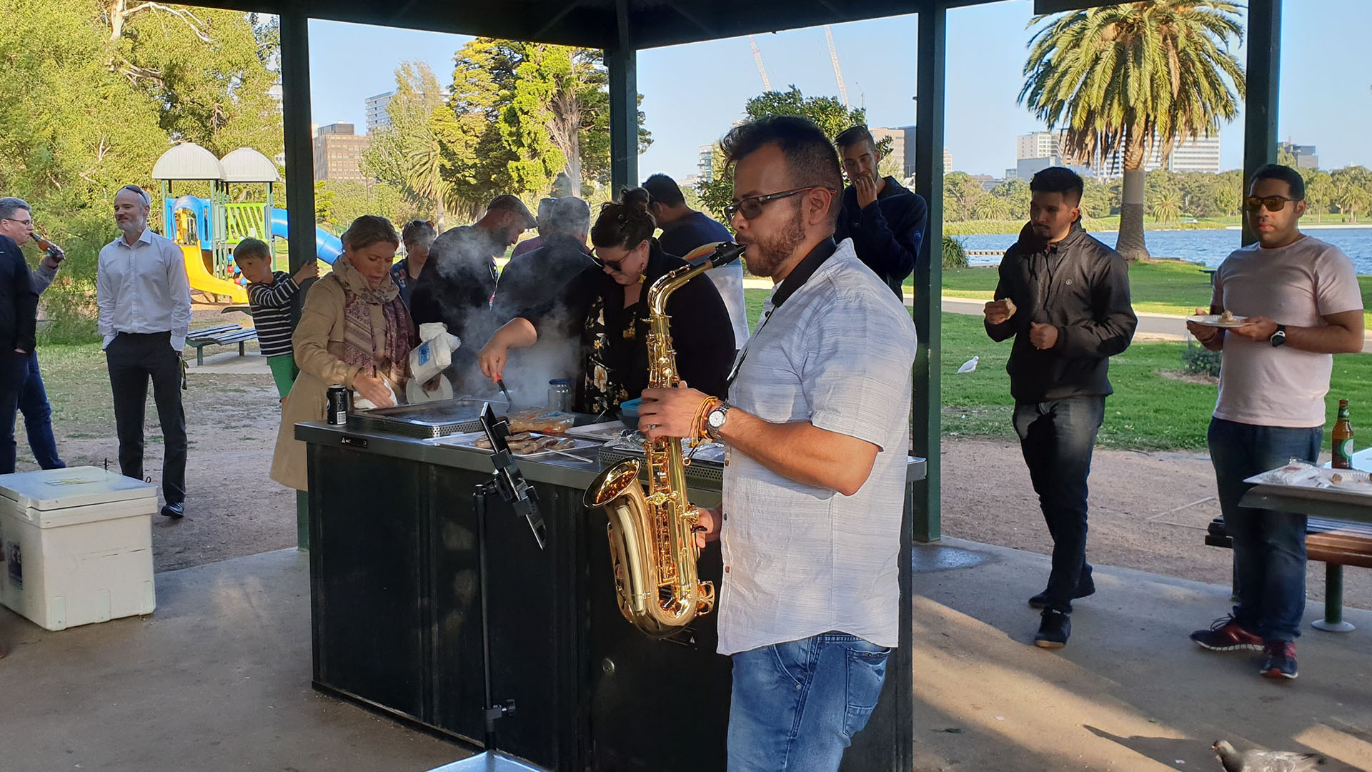 imc employee playing saxaphone at a bbq